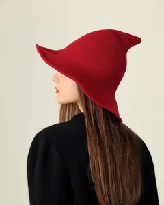 Side profile view of a red knitted pointed witch hat showing fine weave texture details.