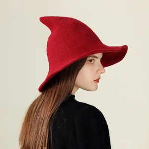 Close-up side view of a vibrant red knitted witch hat featuring a pointed top design