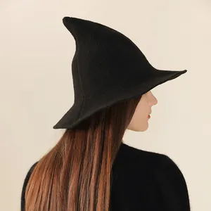 Detail view of a black knitted pointed witch hat for Halloween costume accessory