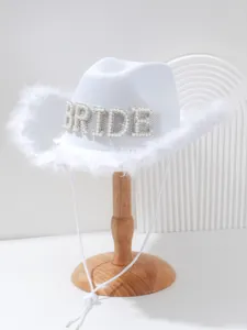Macro detail view of white bride cowboy hat with pearl BRIDE letters and feather trim