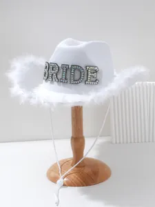 Detailed view of white bridal cowboy hat with rhinestone BRIDE letters and feathers
