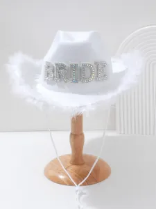 Close-up of white bridal cowboy hat featuring feather trim and rhinestone BRIDE text