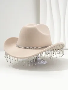 Detailopname van een beige vilten cowboyhoed met fonkelende kwastjes van strassteen