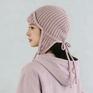 Cappello invernale in maglia rosa con paraorecchi e laccetti per donna su modella