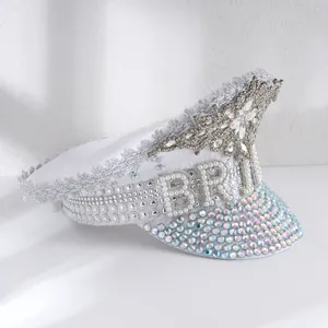Close-up detail of white military style bride hat with pearl lettering and rhinestone jewels