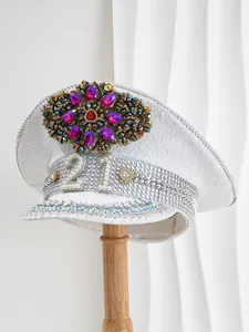 Detalle de gorra de capitán con lentejuelas blancas, número 21 de perlas y flor de strass