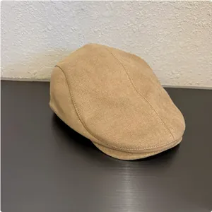 Close-up of a coffee-colored suede retro flat cap showcasing the soft fabric texture