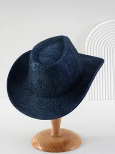 Detailopname van een marineblauwe wollen cowboyhoed met brede rand op houten voet