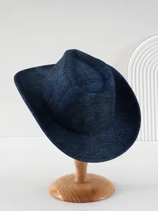 Gedetailleerd overzicht van een donkerblauwe denim cowboyhoed op een houten standaard