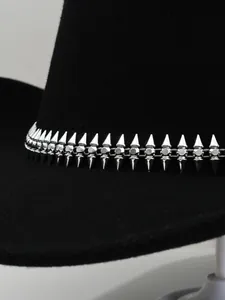 Vista detallada de la banda decorativa con pinchos plateados en un sombrero de fieltro