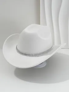 Detalle de un sombrero fedora de fieltro blanco con banda decorativa de pinchos plateados