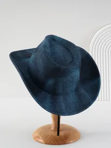 Detailweergave van een marineblauwe wollen hoed met brede rand op houten voet.