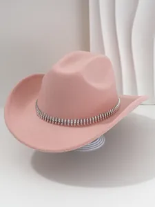 Primer plano de un sombrero de vaquero de fieltro rosa con banda decorativa de tachuelas.