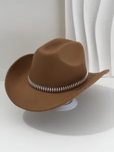 Detalle de un sombrero de vaquero de fieltro marrón con decoración de púas plateadas.