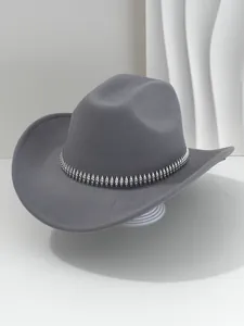 Vista detallada de un sombrero de vaquero de fieltro gris con banda de tachuelas