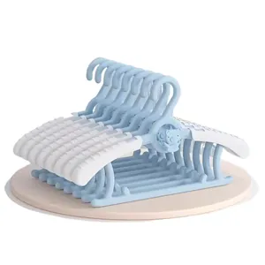 Stack of adjustable blue and white plastic hangers for baby and children's clothes