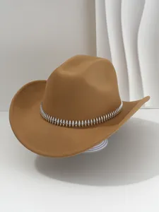 Vista detallada de un sombrero fedora marrón con banda plateada de remaches y pedrería.