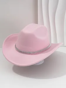 Detalle de sombrero vaquero rosa con banda de pinchos plateados y diamantes imitación.