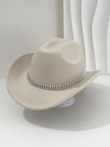 Primer plano de sombrero de fieltro beige con banda de tachuelas plateadas y strass
