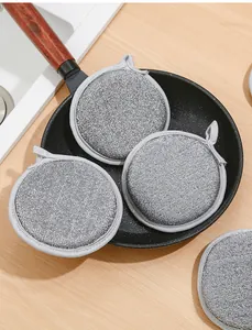 Macro detail of grey metallic dishwashing scouring pads placed inside a black frying pan