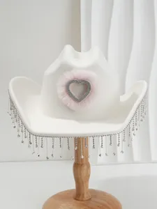 Macro view of bridal white cowboy hat with pink furry rhinestone heart and hanging tassels