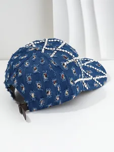 Detalle de gorra vaquera desgastada con patrón de estrellas de pedrería y correa ajustable
