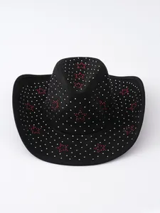 Dettaglio ravvicinato delle stelle di strass rossi su un cappello da cowboy nero