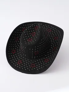 Primo piano di cappello da cowboy scamosciato nero con stelle di strass rossi e puntini