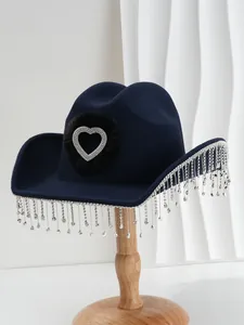 Detailed close-up of black cowboy hat featuring a rhinestone heart and crystal tassels