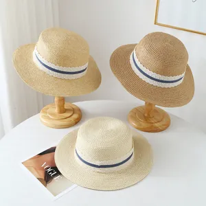 Detail of three French raffia straw hats with lace trim for summer beach sun protection.