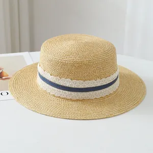 Close-up detail of a French Raffia straw hat featuring white lace and a blue striped band