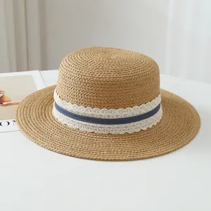 Detailed view of French raffia straw sun hat featuring white lace and blue ribbon