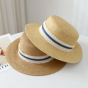 Close-up of French raffia straw hats with elegant lace and blue stripe ribbon detail