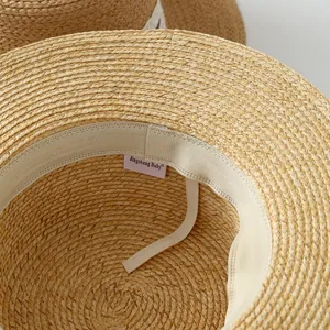 Detail view of the interior sweatband and brand label of a French raffia straw hat