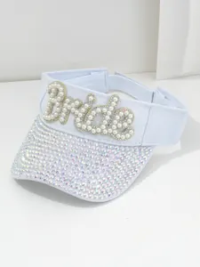 Vista dettagliata di una visiera bianca con scritta Bride in perle e strass luccicanti