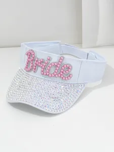 Dettaglio di una visiera bianca con scritte Bride in perle e dettagli in strass.