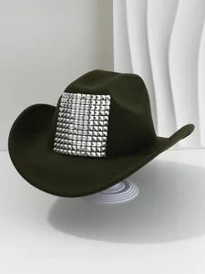 Close-up of a dark olive cowboy hat featuring a large silver pyramid stud patch