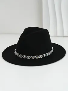 Close-up of black felt fedora hat with iridescent crystal eye-patterned band.