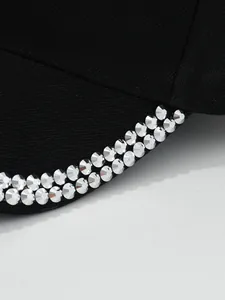 Detail shot showing double rows of silver metal rivets on black curved brim baseball cap