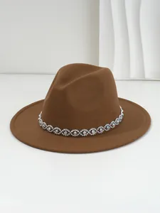 Close-up detail of a brown felt fedora hat with a shimmering bohemian crystal band.