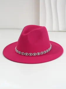 Close-up of a magenta felt fedora hat with a bohemian eye-shaped rhinestone decorative band