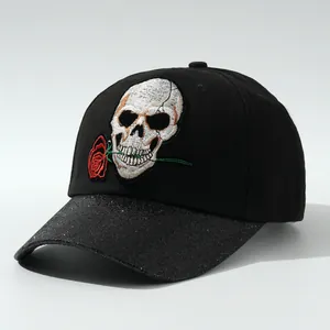 Dettaglio cappello nero con ricamo teschio e rosa e visiera glitterata