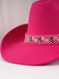 Detailansicht eines rosa Filz-Cowboyhuts mit Rosenstickerei und Spitzenband-Akzenten.