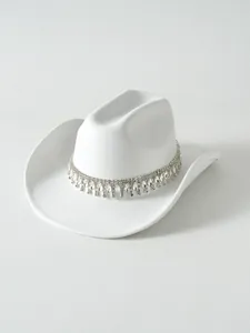 Primo piano di un cappello da cowboy bianco con frange di strass e pendenti di cristallo brillante