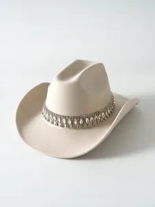 Dettaglio di un cappello da cowboy in feltro beige con frangia in strass scintillanti