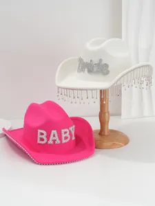 Close-up of two western cowboy hats with 'Bride' and 'BABY' rhinestone letters and fringe