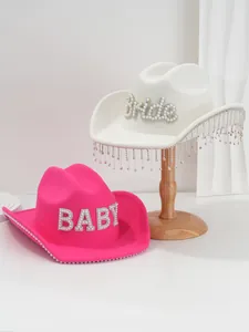 Close-up of white and pink felt cowboy hats decorated with pearl Bride and BABY letters
