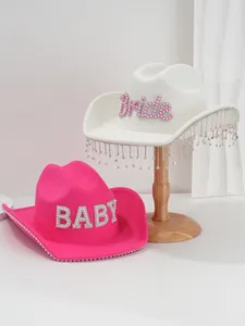 Detailed view of pearl rhinestone letters and tassel fringe on stylish cowboy hats