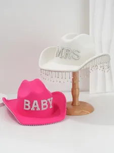 Detailed macro view of white MRS and pink BABY wool cowboy hats with pearls and fringe