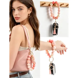 Silicone bead keychain wristlet with tassel and heart stone on pink bag and wrist.